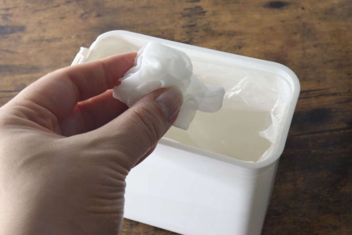 ダストボックスに白いゴミを捨てている手元