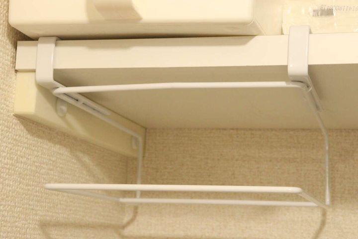 吊り戸棚の下に白いラックが取り付けられている様子