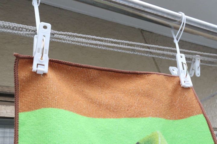物干し竿に白い洗濯ピンチでタオルが2枚干されている