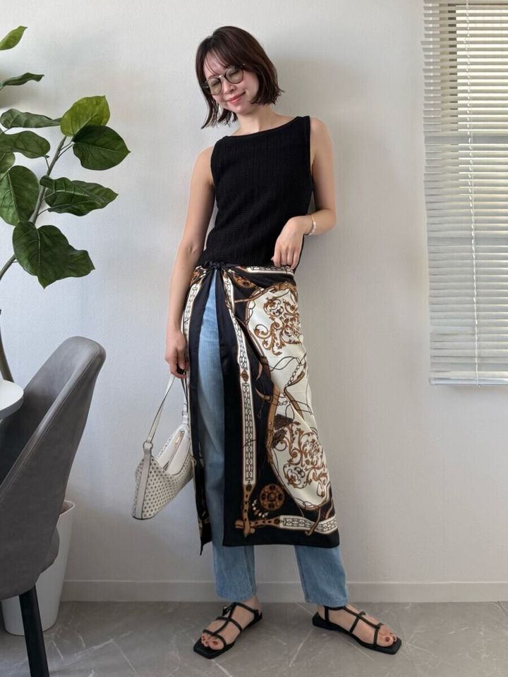 黒いニットタンクトップとデニムにスカーフを巻いた女性の全身コーデ