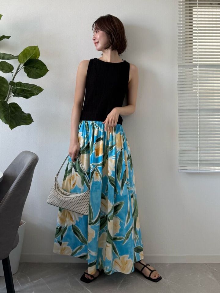 黒いニットタンクトップと花柄スカートを合わせた女性の全身コーデ