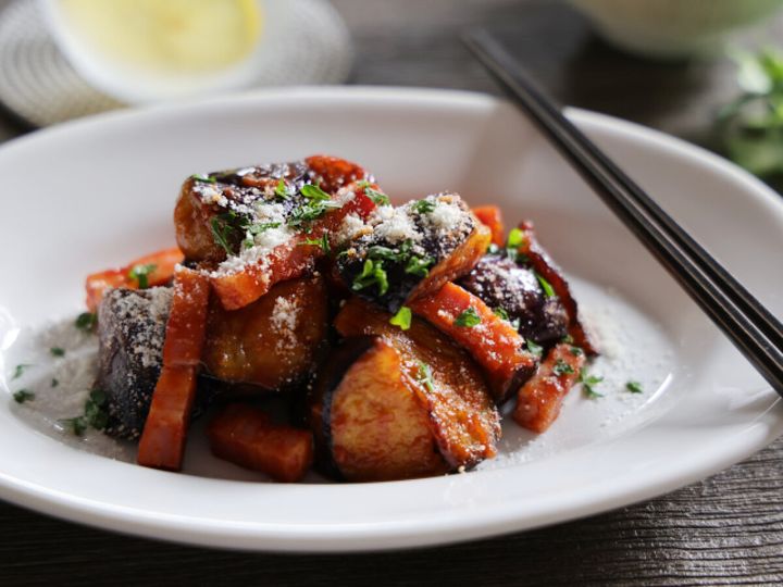 白い皿に盛られたなすとベーコンの和風ケチャップ炒め。粉チーズと刻みパセリが散らされている。
