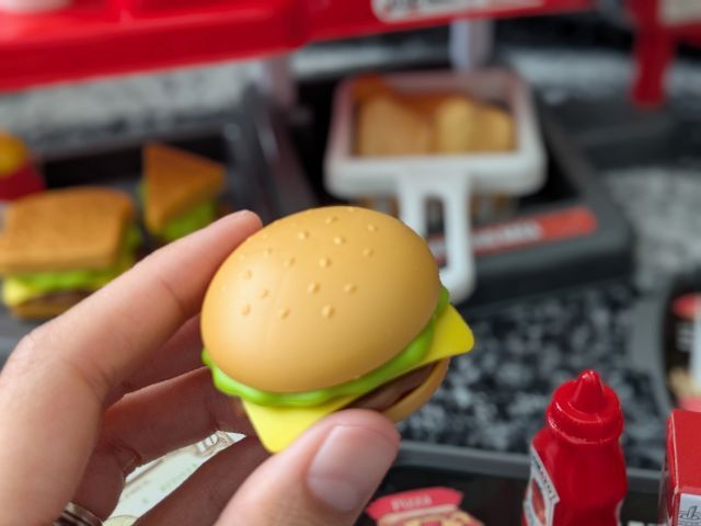 手に持ったハンバーガー型のおもちゃのアップ