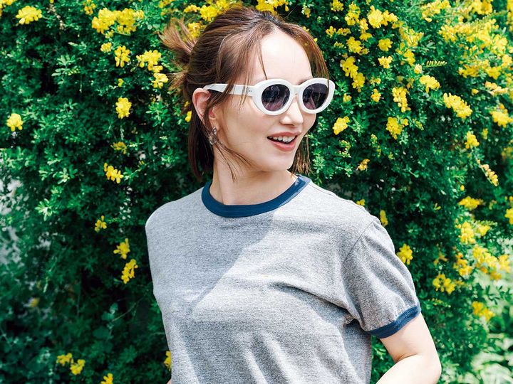 アヤメの白フレームサングラスをかけるTシャツ姿のモデル