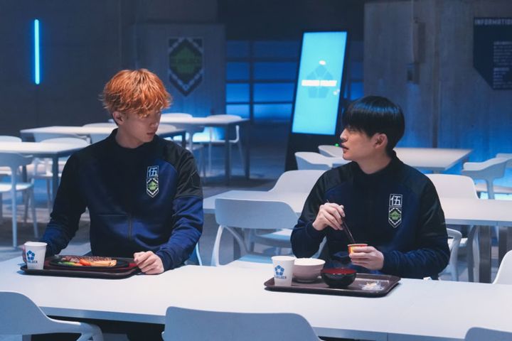 映画『ブルーロック』より食堂で会話する國神錬介（野村康太）と潔世一（高橋文哉）