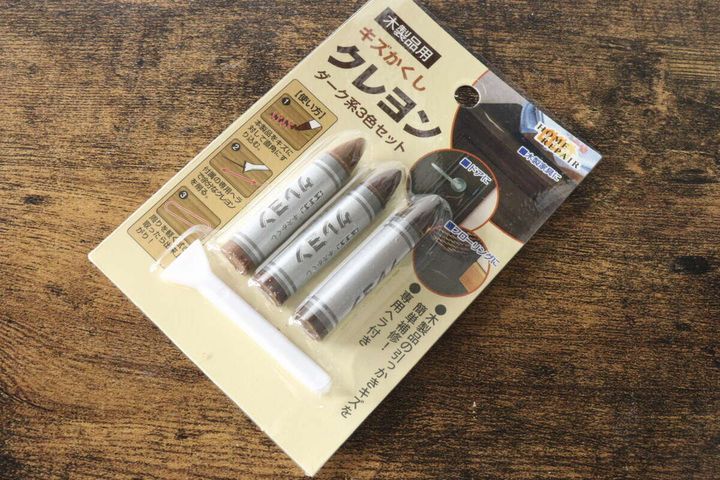 木目調のテーブルに置かれた「木製品用キズかくしクレヨン」のパッケージ