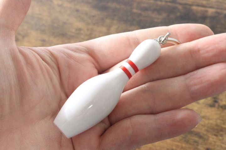 女性の手のひらに乗せられたボウリングピン