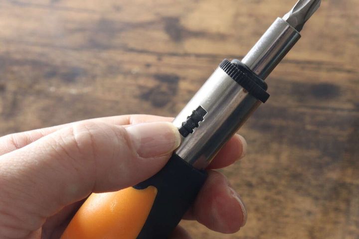 女性の手がラチェットドライバーのギアを切り替えている様子