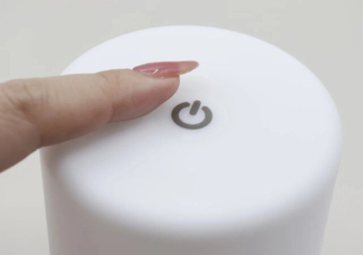 指が白いランタンの電源マークに触れている