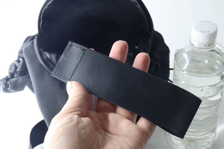 手で持った「貼るだけポケット」とバッグ、ペットボトル