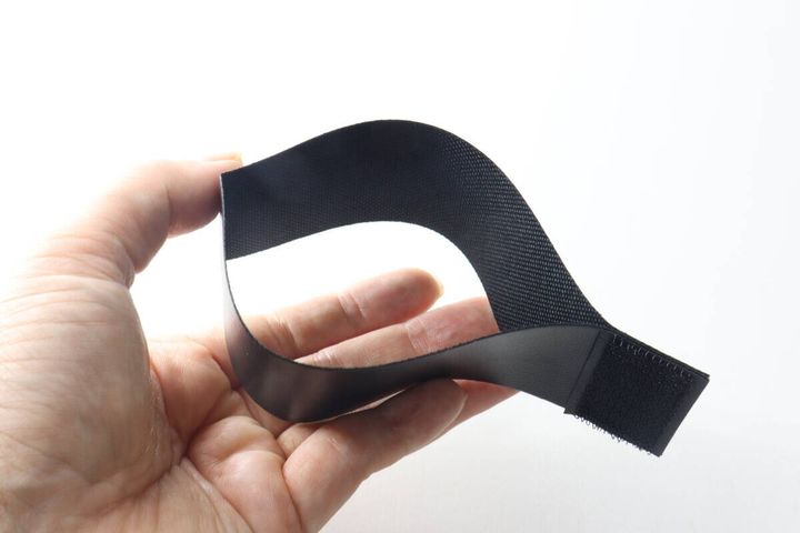 手で「貼るだけポケット」を筒状に曲げている様子