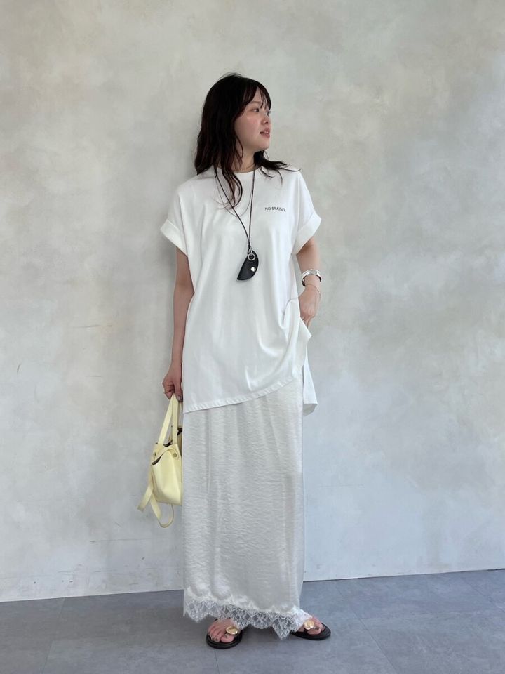 白のチュニックTシャツと裾レースのロングスカートのワントーンコーデの女性