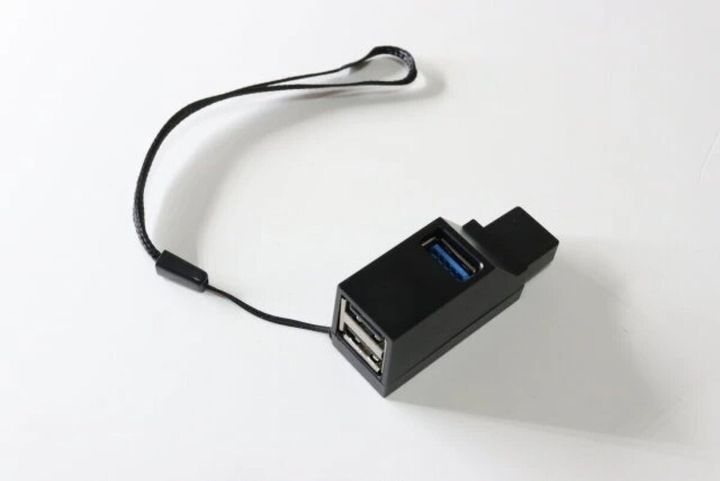 黒いUSBハブとストラップが白い背景に置かれている