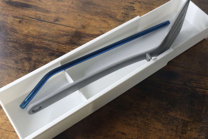白い伸縮ケースに青いストローとグレーのトングを収納している様子