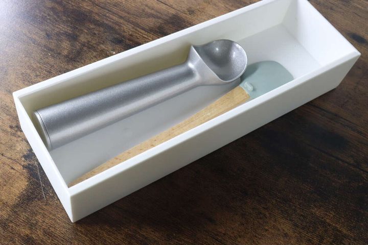 白い伸縮ケースにアイスクリームスクープとヘラを収納している様子