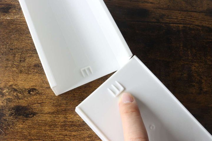 白い伸縮ケースのストッパーの突起部分を指で示しているクローズアップ