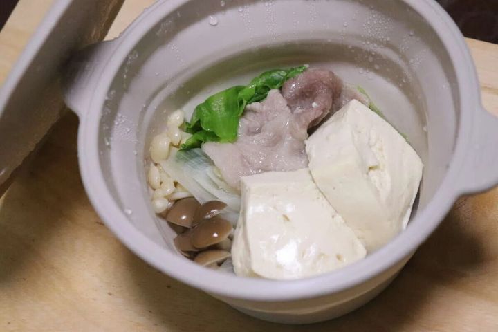 シリコーン小鍋に豚肉、豆腐、きのこ、葉物野菜が入れられている
