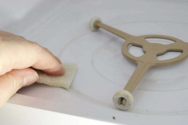 電子レンジ庫内の汚れをセスキ炭酸ソーダクリーナーで拭く手元