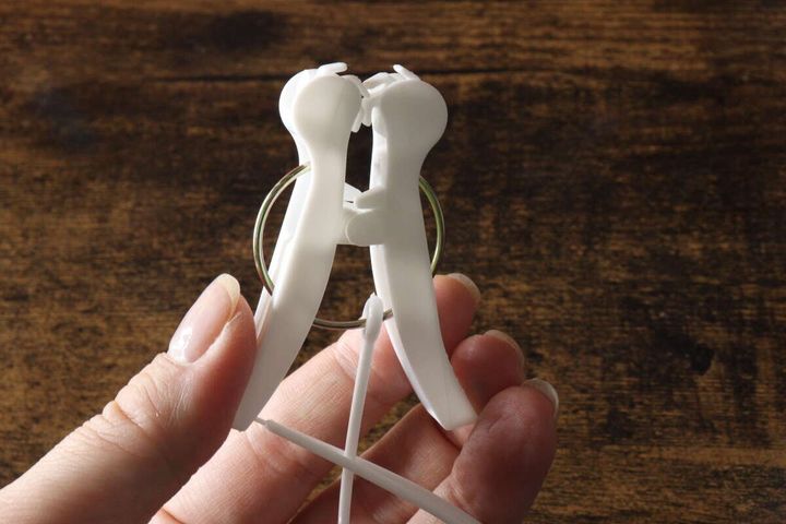 指で白い洗濯ピンチを開閉している様子