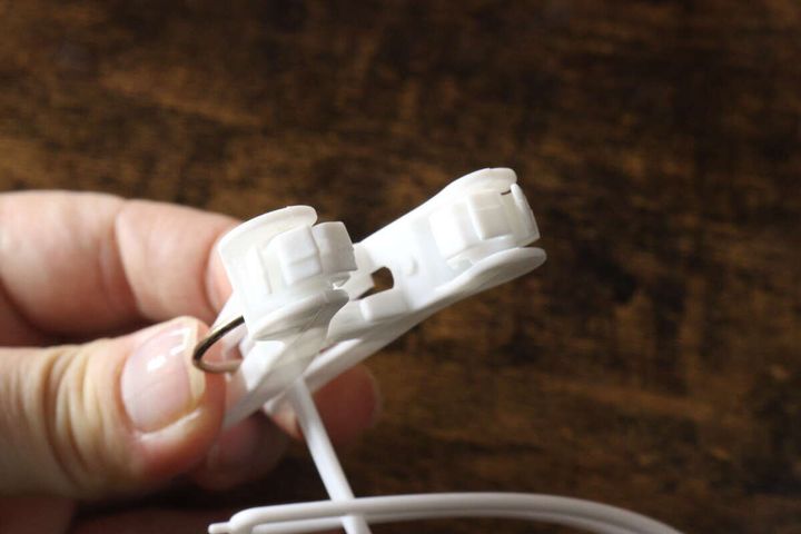 指で白い洗濯ピンチの先端の回転構造を見せている