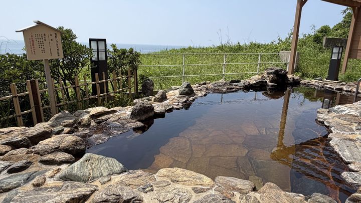 青い空と海を望む岩造りの開放的な露天風呂