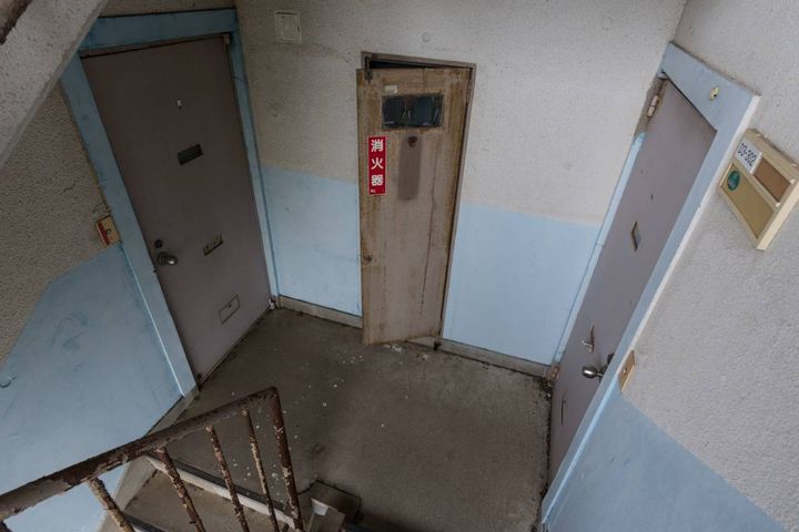 古い団地の踊り場にある、消火器置き場の扉