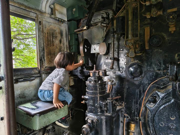 SLの機関室で運転席に座る子どもの後ろ姿