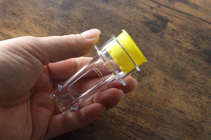 透明なレモンジューサー本体を手に持っている様子