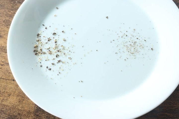 白い皿の上に粗く挽かれた胡椒と細かく挽かれた胡椒が並んでいる