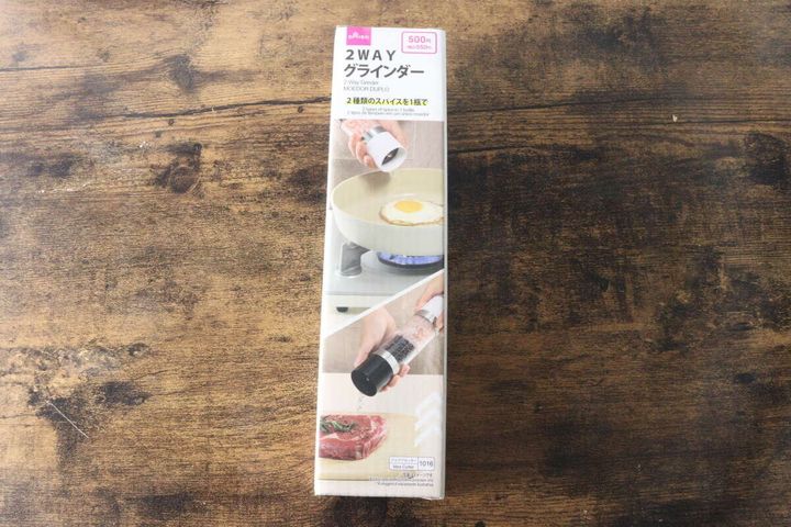 木目のテーブルに置かれたダイソー2WAYグラインダーのパッケージ