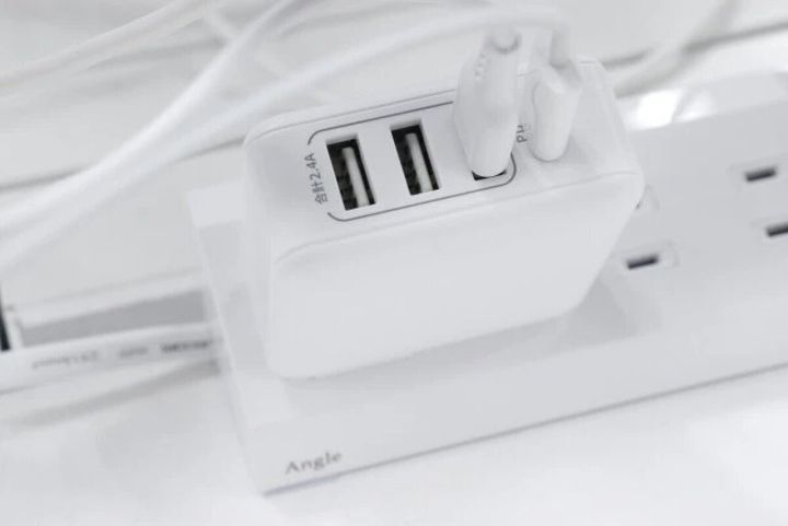 コンセントに挿された白いUSB ACアダプター充電器にケーブルが接続されている
