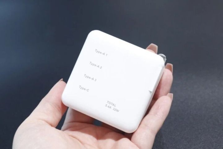 女性の手のひらに乗せられた白いUSB ACアダプター充電器