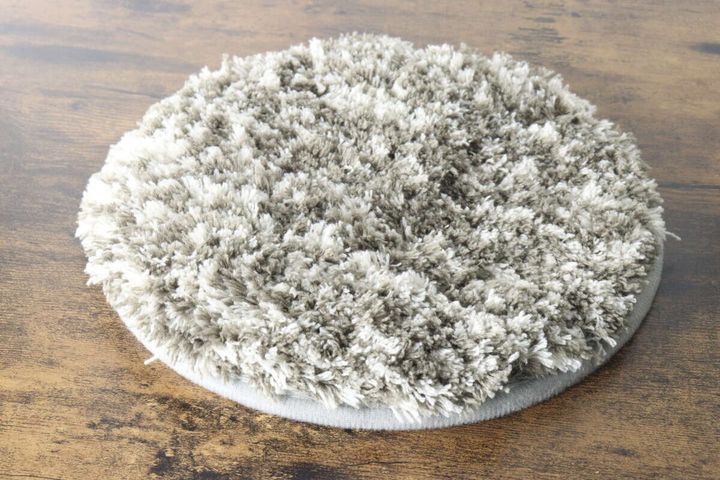 木目のテーブルに置かれたタグなしの丸いタフティングマット