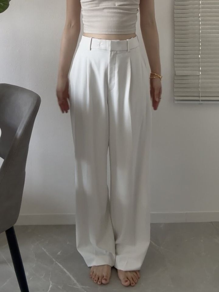 白いタックワイドパンツを着用した女性の全身