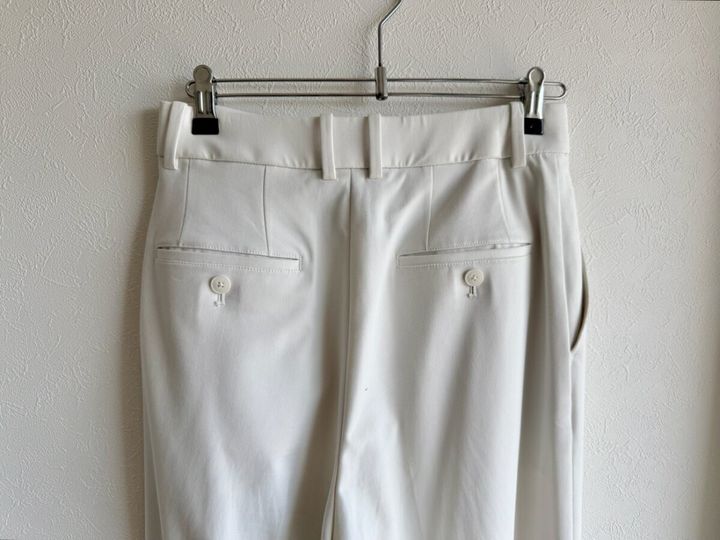 白いタックワイドパンツの後ろウエスト部分、ポケットにボタン付き