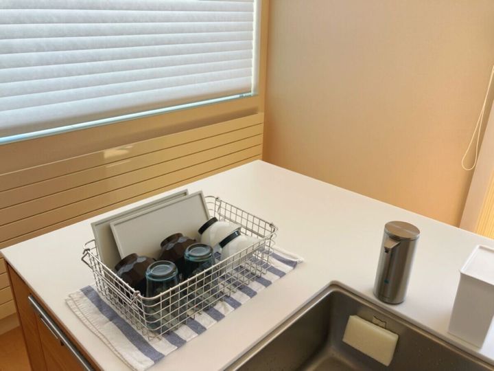 白いカウンターキッチンに置かれた水切りかご