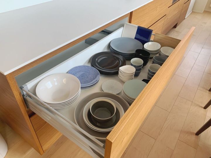 引き出し式の食器棚にきれいに並べられた様々な食器