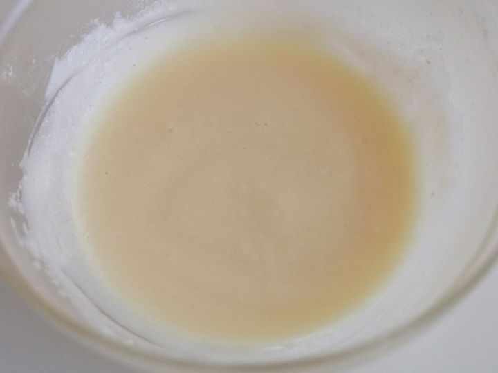 透明なボウルに入った乳白色の液体（ヨーグルト、米油、砂糖、レモン汁）の俯瞰