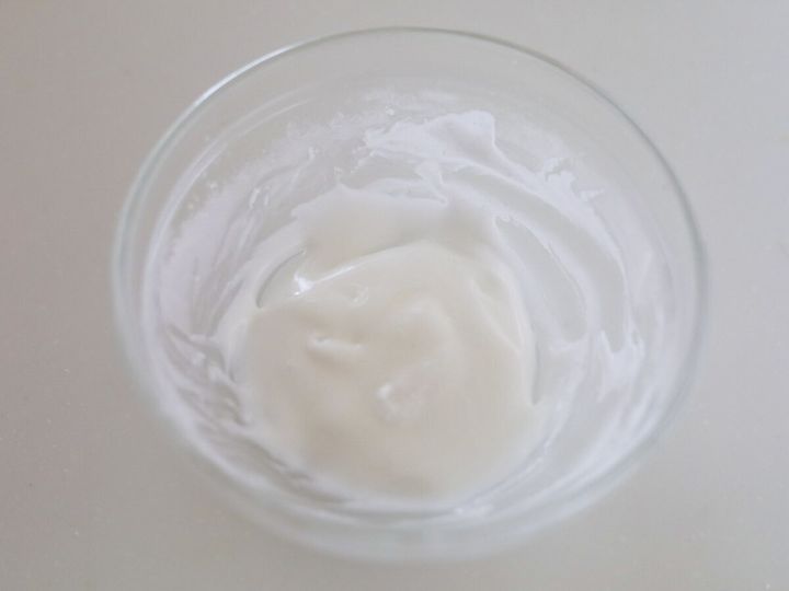 透明なボウルの中で、粉糖とレモン汁を混ぜて作られた白いアイシング
