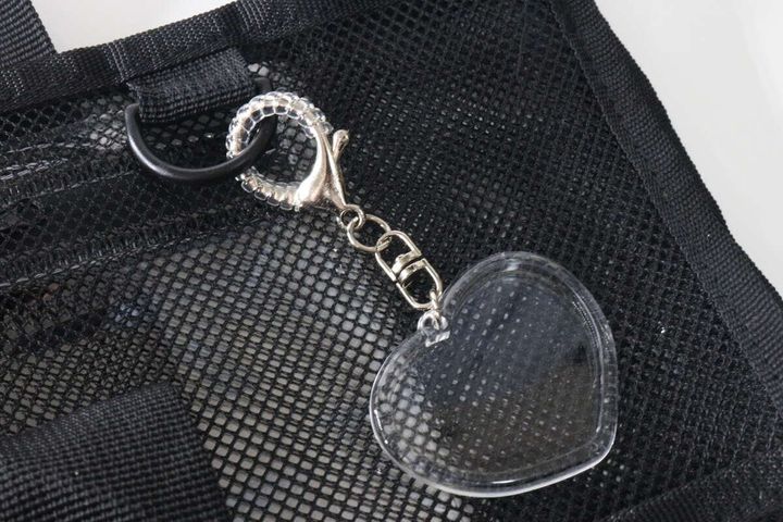 透明なコイルを装着したハート型キーホルダーが黒いバッグに付いている