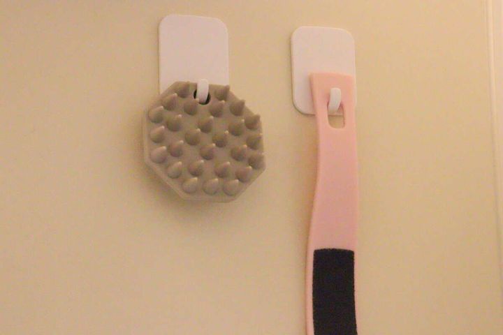 お風呂の壁にフックで吊るされているピンク色のかかとやすり