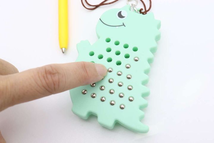 指でキーホルダーの裏からボールを押し出してバラバラにしている様子