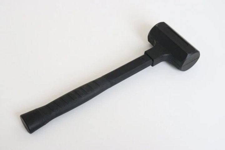 黒いショックレスハンマーが白い背景に置かれている
