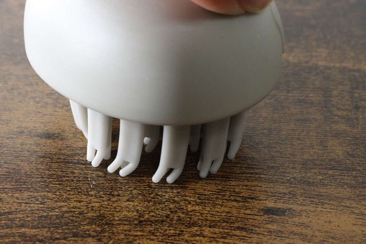 足で立つシャンプーブラシがテーブルの上に自立している