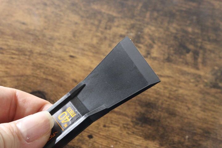 手が40mm幅のヘラの先端部分を握り、刃先の薄さやしなりがわかるように見せている