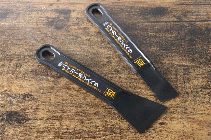 パッケージから取り出された2種類の黒いヘラが木目のテーブルに並べられている