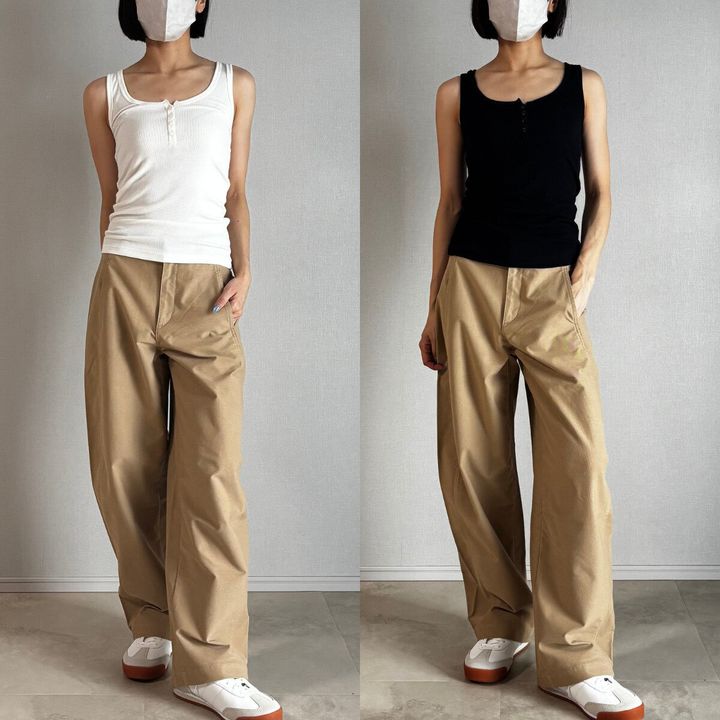 白と黒のタンクトップとベージュパンツを着用した女性