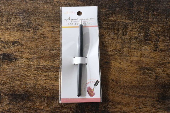 木目のテーブルに置かれたセリアのマグネットピックアップペンのパッケージ