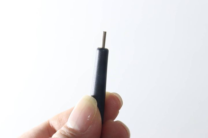 指で持たれたマグネットピックアップペンの先端部分のアップ