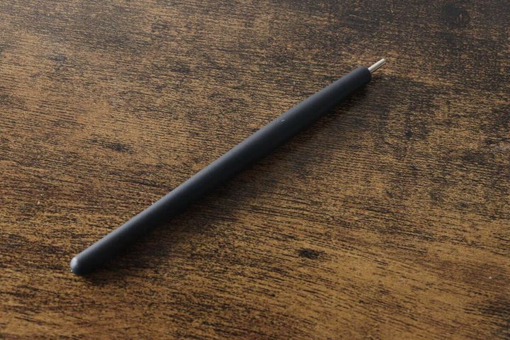木目のテーブルに置かれた黒いマグネットピックアップペン本体